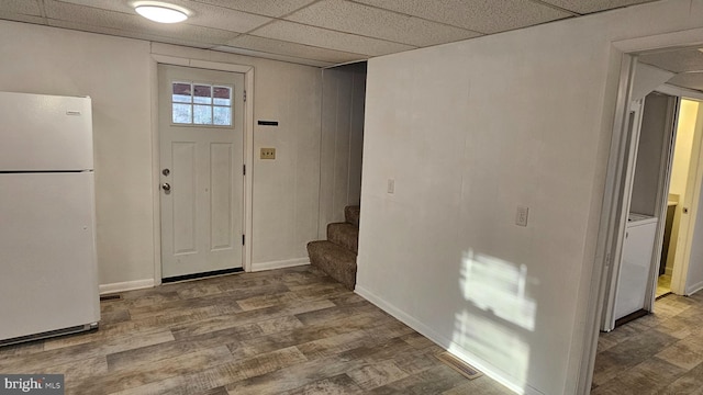 foyer entrance featuring visible vents, wood finished floors, stairway, baseboards, and a paneled ceiling