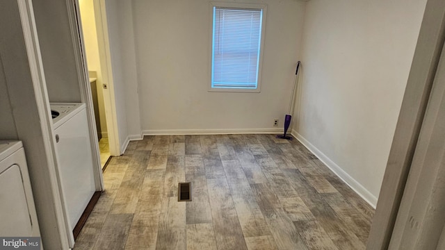 clothes washing area featuring baseboards, washer / clothes dryer, wood finished floors, and laundry area