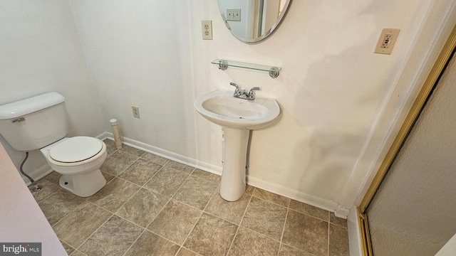 bathroom with toilet and baseboards