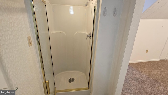 full bath featuring a shower stall and baseboards