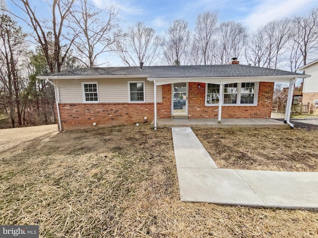 single story home with brick siding and a chimney