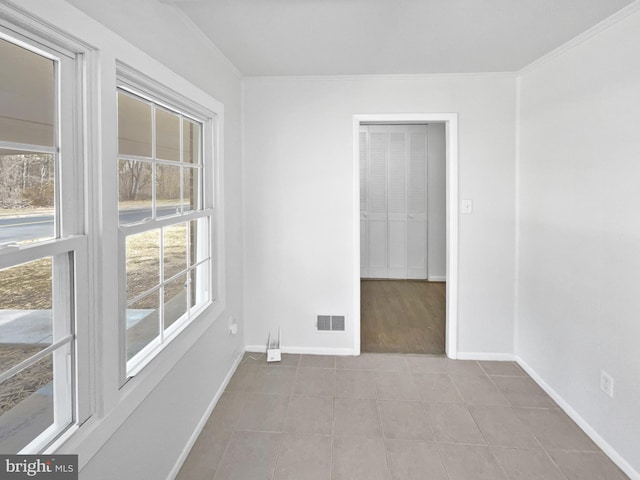 spare room featuring visible vents, baseboards, and ornamental molding