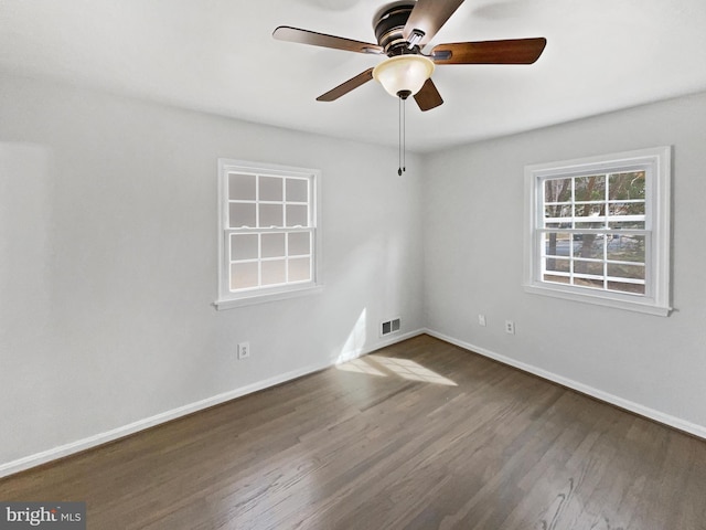 unfurnished room featuring a ceiling fan, visible vents, wood finished floors, and baseboards