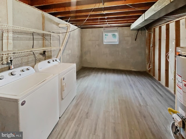 laundry room featuring water heater, laundry area, washing machine and dryer, and light wood-style floors