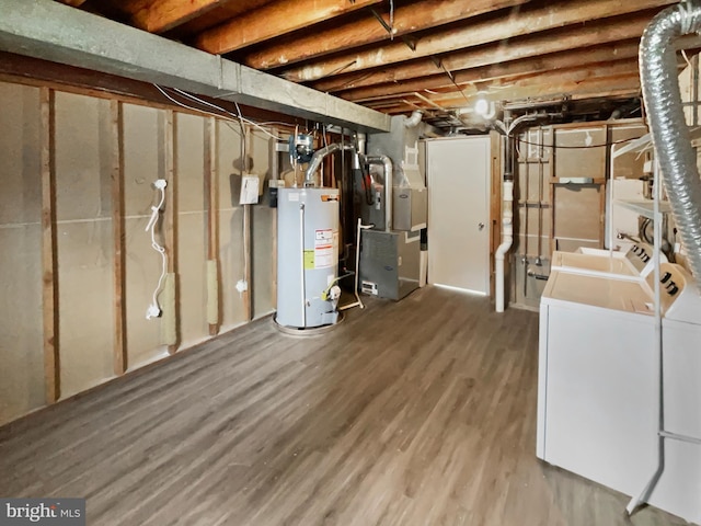 unfinished below grade area featuring heating unit, wood finished floors, a sink, washer and dryer, and gas water heater