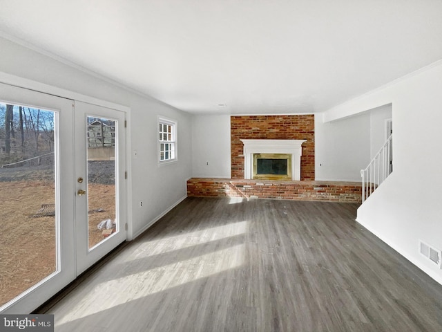 unfurnished living room featuring visible vents, stairs, a fireplace, french doors, and wood finished floors