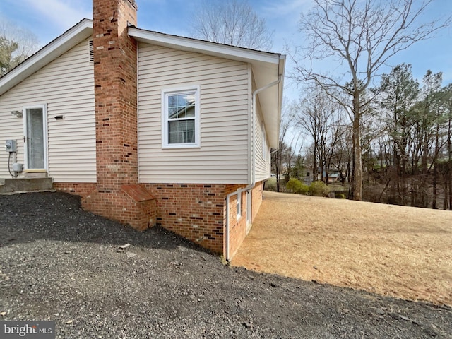 view of side of home featuring entry steps and a chimney