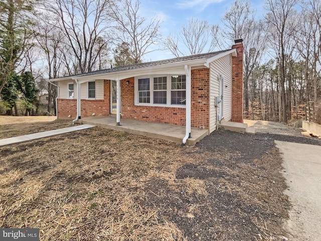 single story home with brick siding and a chimney