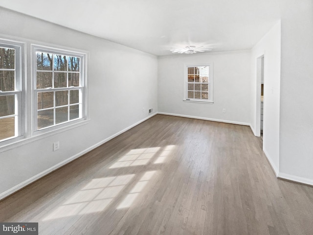 unfurnished room with baseboards and wood finished floors