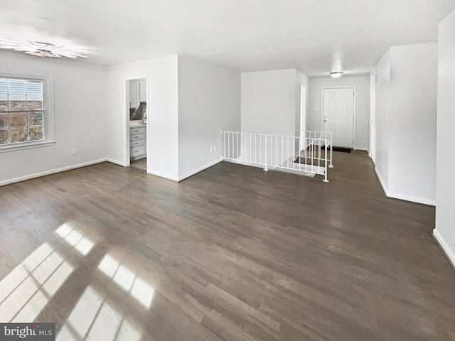 unfurnished room with dark wood-style floors and baseboards