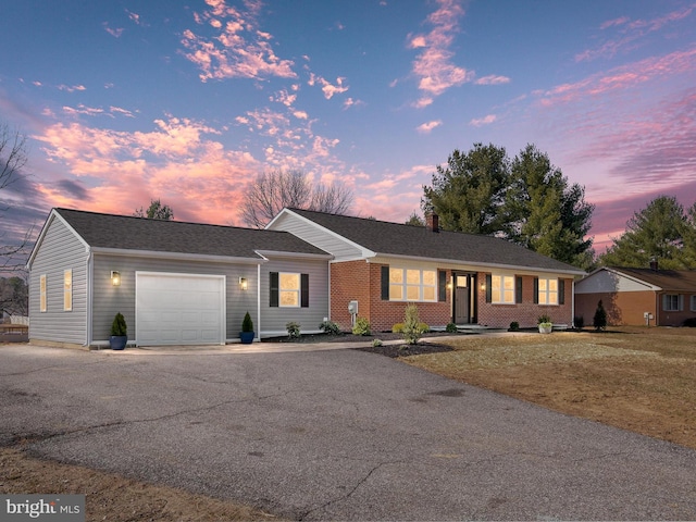 ranch-style home with driveway, brick siding, and an attached garage