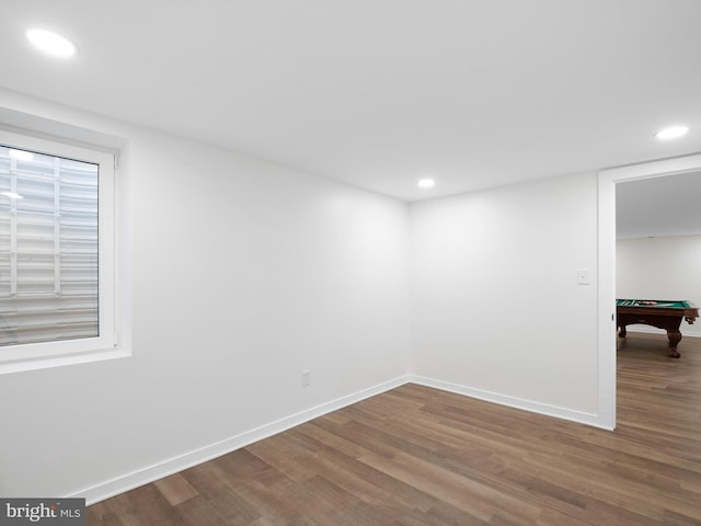 unfurnished room with pool table, baseboards, and wood finished floors