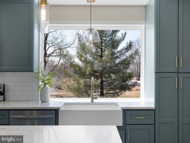 interior space with decorative light fixtures, dishwasher, light stone counters, decorative backsplash, and a sink