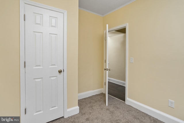 unfurnished bedroom with crown molding, baseboards, and carpet floors