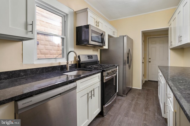 kitchen featuring a sink, stainless steel appliances, crown molding, and white cabinetry