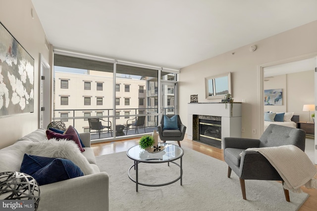 living area featuring a high end fireplace, expansive windows, and wood finished floors