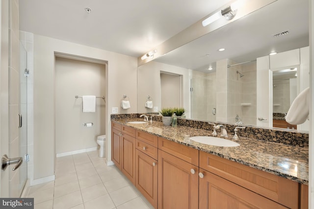 full bathroom with a sink, double vanity, a shower stall, and tile patterned flooring