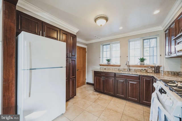 kitchen featuring dark brown cabinets, ornamental molding, light stone counters, white appliances, and a sink