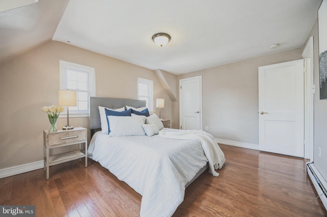 bedroom with baseboards, baseboard heating, lofted ceiling, and wood finished floors