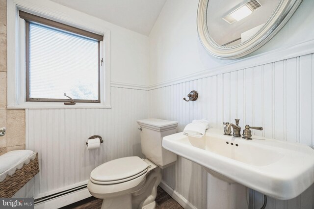 bathroom featuring wood finished floors, a baseboard radiator, a sink, wainscoting, and toilet