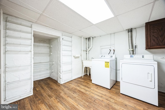 clothes washing area with washer and dryer, light wood-style floors, and laundry area