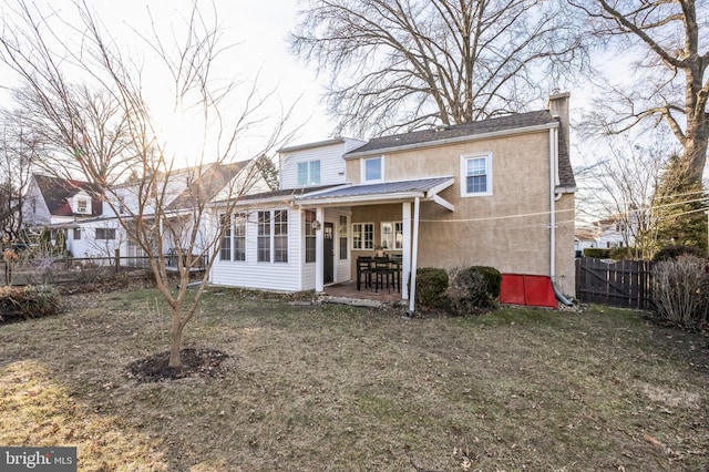 rear view of house with a patio area, stucco siding, a chimney, and a fenced backyard