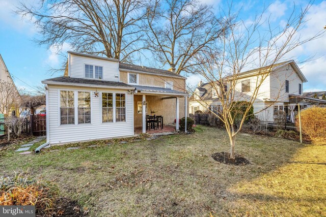 rear view of house featuring a yard, a patio area, and fence