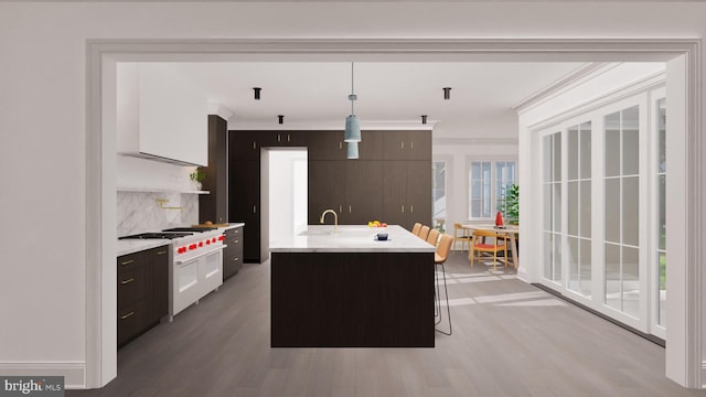 kitchen featuring ornamental molding, light countertops, range with gas cooktop, decorative light fixtures, and modern cabinets