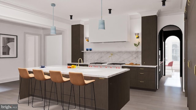 kitchen featuring tasteful backsplash, dark brown cabinets, a breakfast bar, light countertops, and ornamental molding