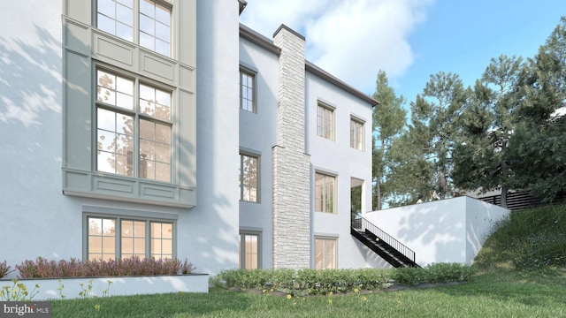 view of side of home featuring stairs and stucco siding