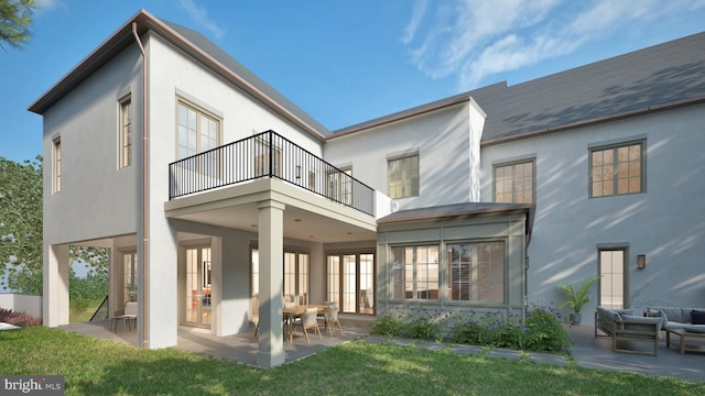 back of property featuring a patio, a balcony, a lawn, and stucco siding