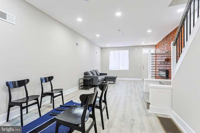 dining area with stairs, light wood finished floors, and visible vents