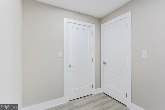 interior space with baseboards and light wood-style floors