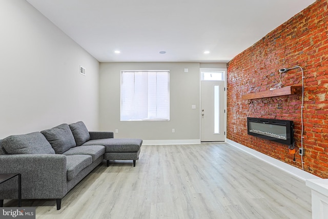 living room featuring wood finished floors, a glass covered fireplace, baseboards, visible vents, and recessed lighting