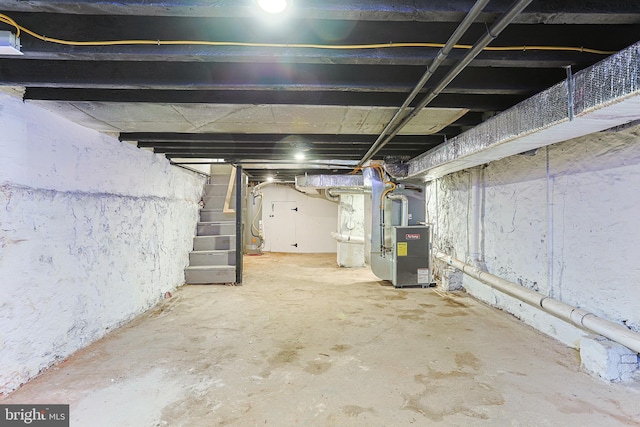 unfinished below grade area featuring heating unit and stairway