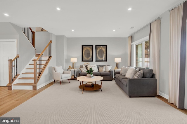 living room featuring stairs, recessed lighting, wood finished floors, and baseboards