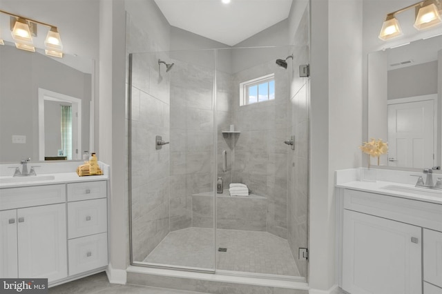 full bathroom featuring a sink, two vanities, and a stall shower