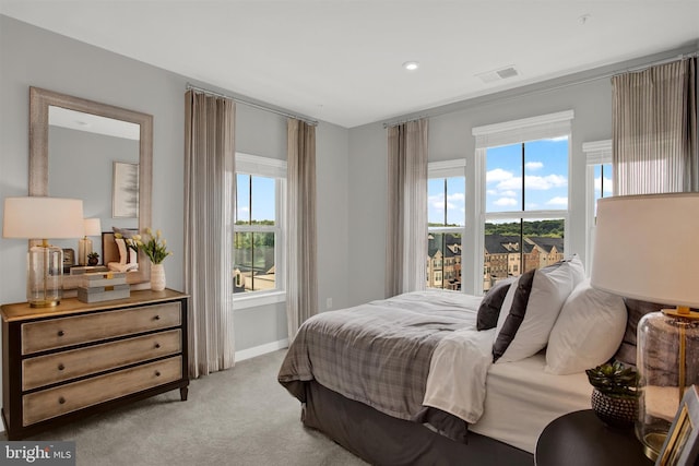 bedroom with visible vents, light colored carpet, and baseboards