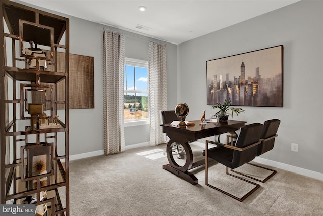 carpeted office space featuring visible vents and baseboards