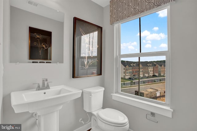 half bathroom with visible vents and toilet