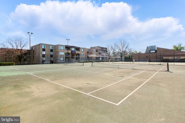 view of tennis court featuring fence