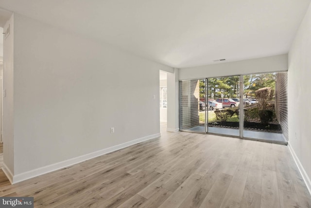 empty room featuring baseboards and wood finished floors