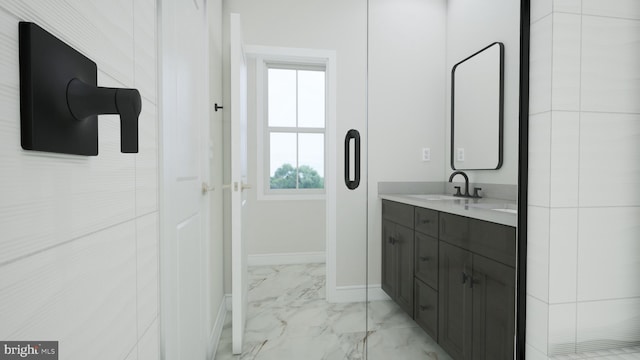 bathroom with marble finish floor, vanity, and baseboards