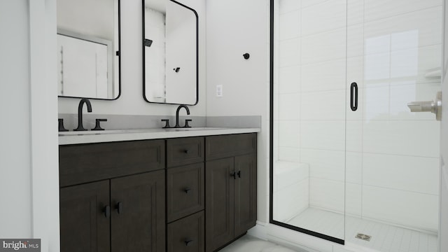 full bath with a shower stall, double vanity, marble finish floor, and a sink