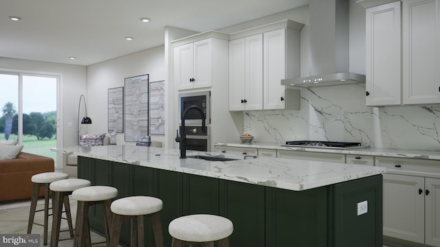 kitchen featuring a kitchen breakfast bar, wall chimney exhaust hood, and backsplash