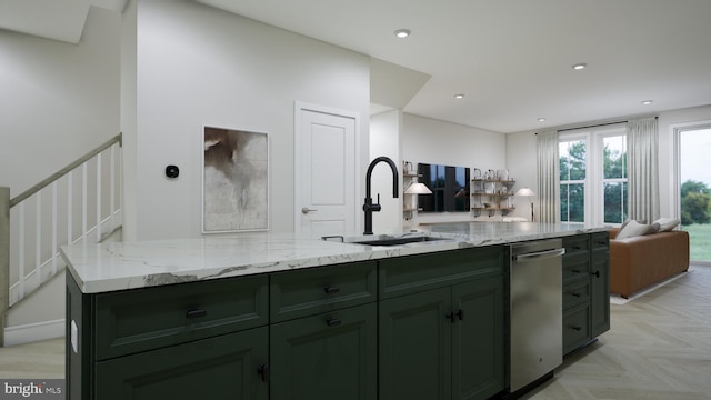 kitchen with a sink, green cabinets, light stone countertops, and open floor plan