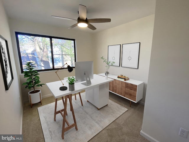 office area with a ceiling fan, baseboards, and carpet floors