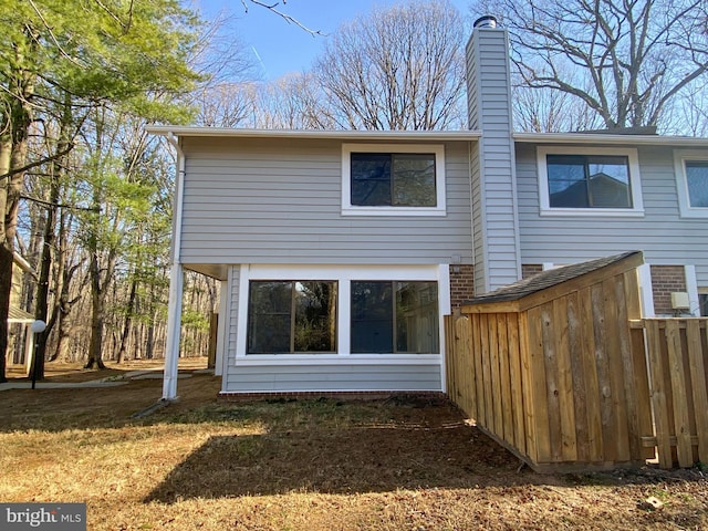 back of house featuring a chimney