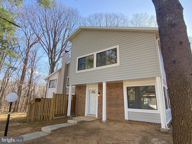 view of front of property with brick siding and a chimney