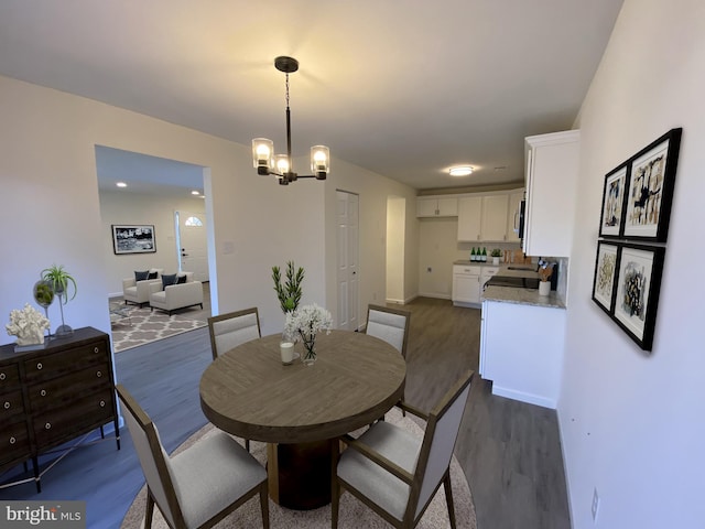 dining area with a chandelier and dark wood-style flooring